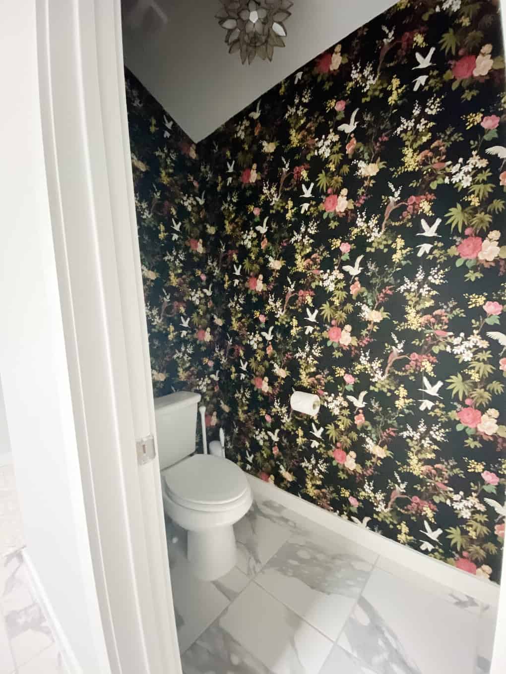 water closet with bold black floral wallpaper 