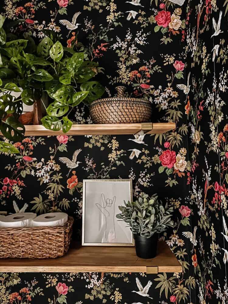 two small, thin shelves above a toilet with decor 