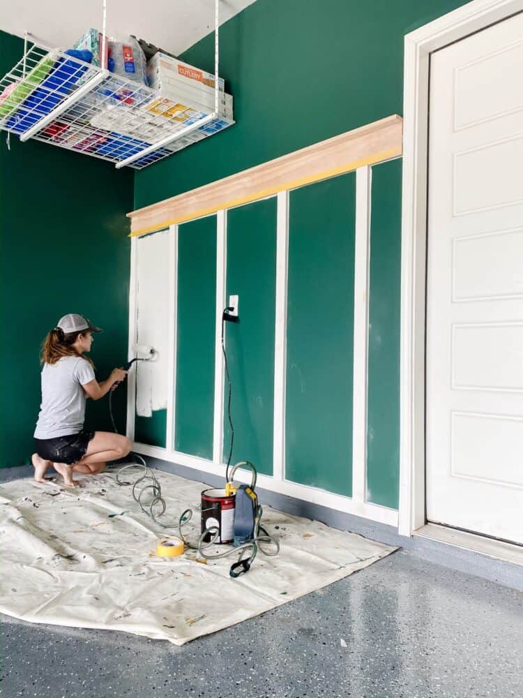 woman using a Wagner SMART Sidekick paint roller to paint a board and batten accent wall 