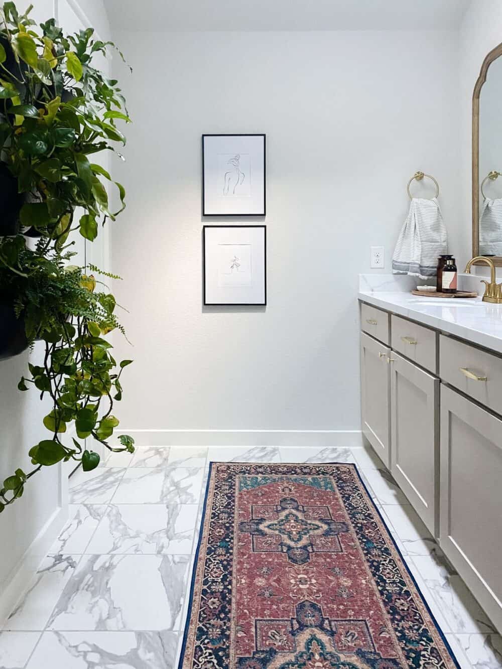 bathroom with taupe vanity and line drawings hanging on wall 