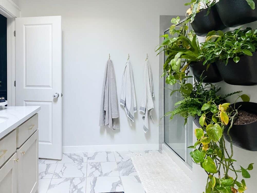 bathroom with plant wall and white faux marble tile 