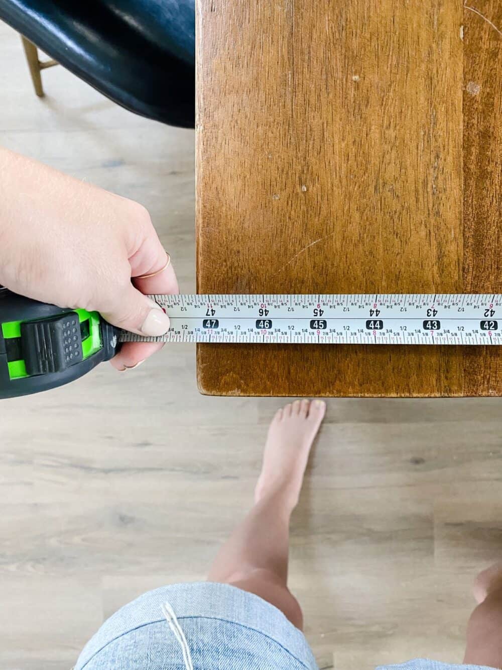 hang using a tape measure to measure a table