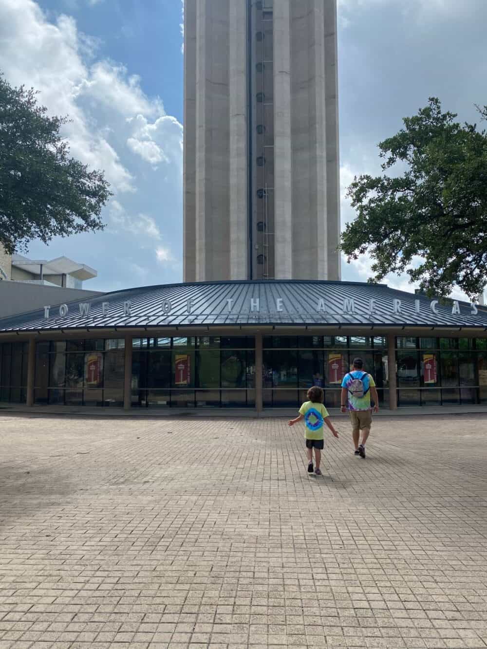 father and son walking up to the Tower of the Americas in San Antonio