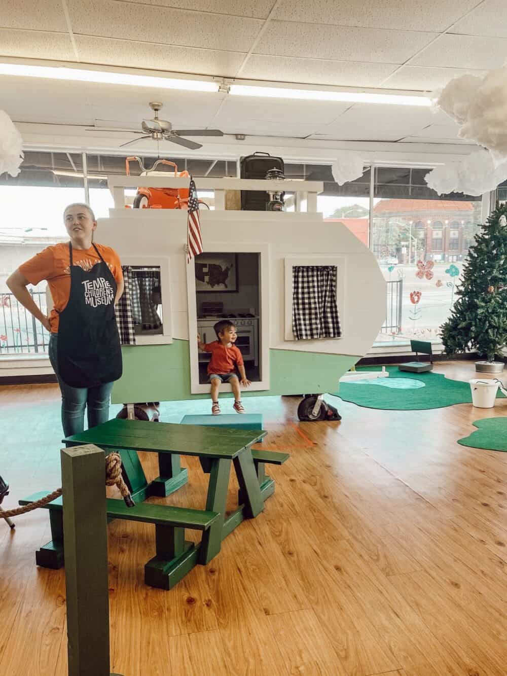 A wooden camper playhouse at a children's museum