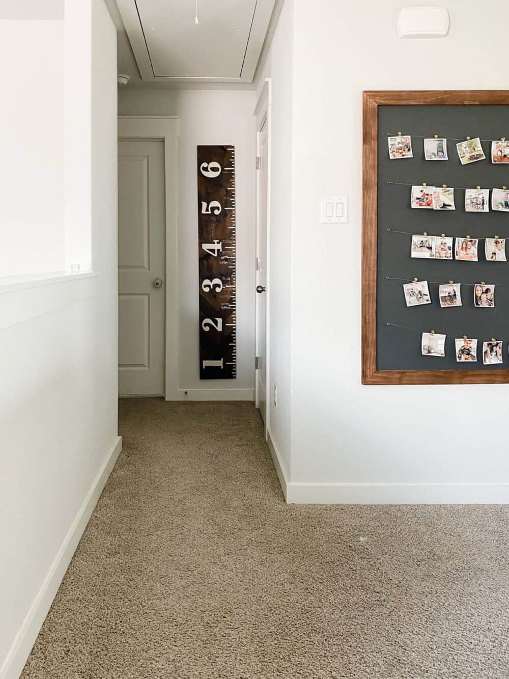 A small hallway with a wooden growth chart ruler hanging on the wall. 