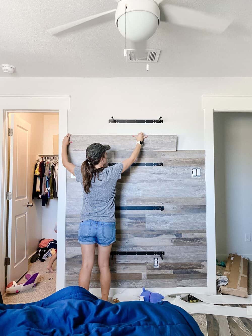Woman installing vinyl planks on accent wall
