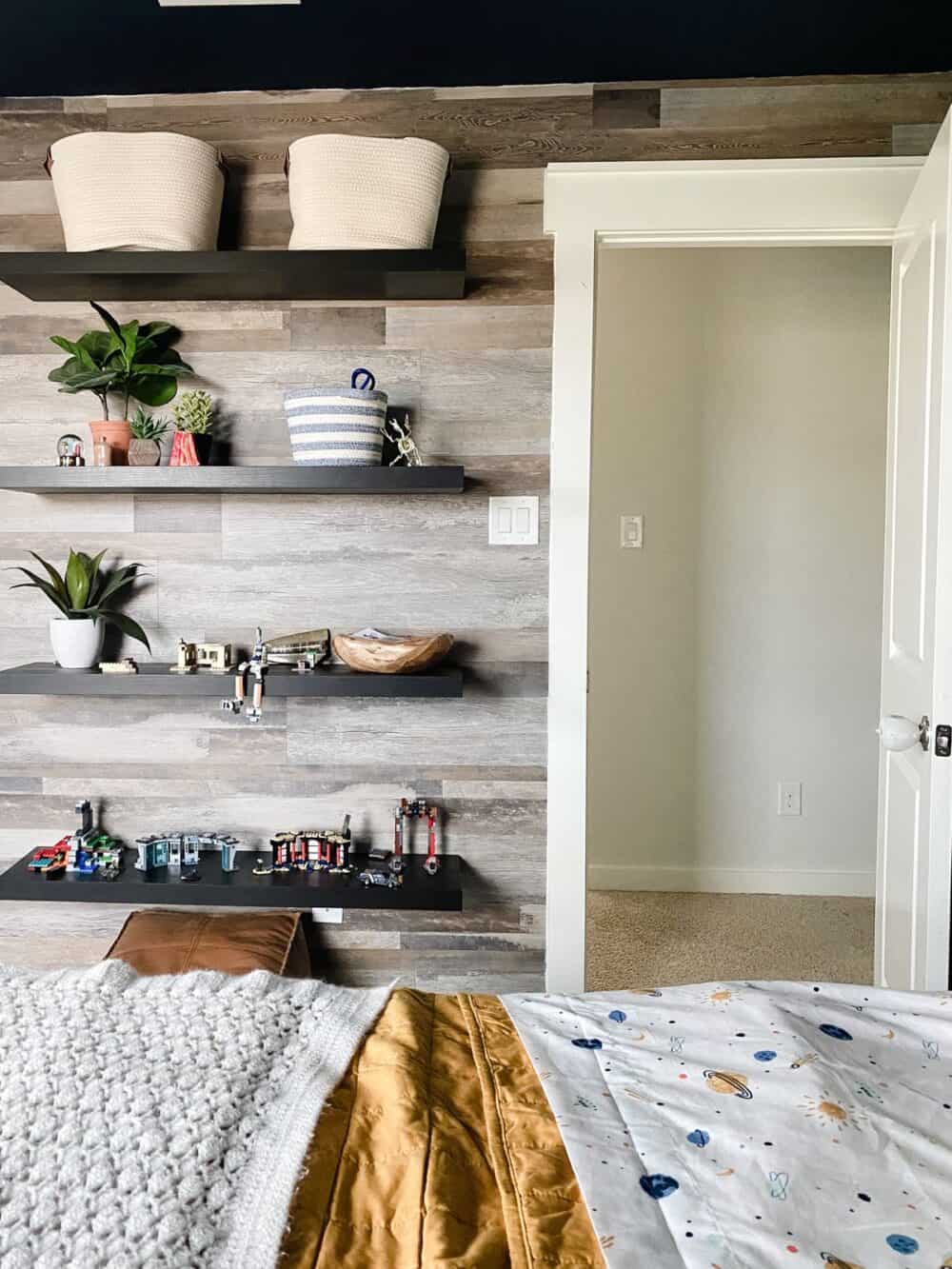 A boys' bedroom with a faux wood vinyl plank accent wall