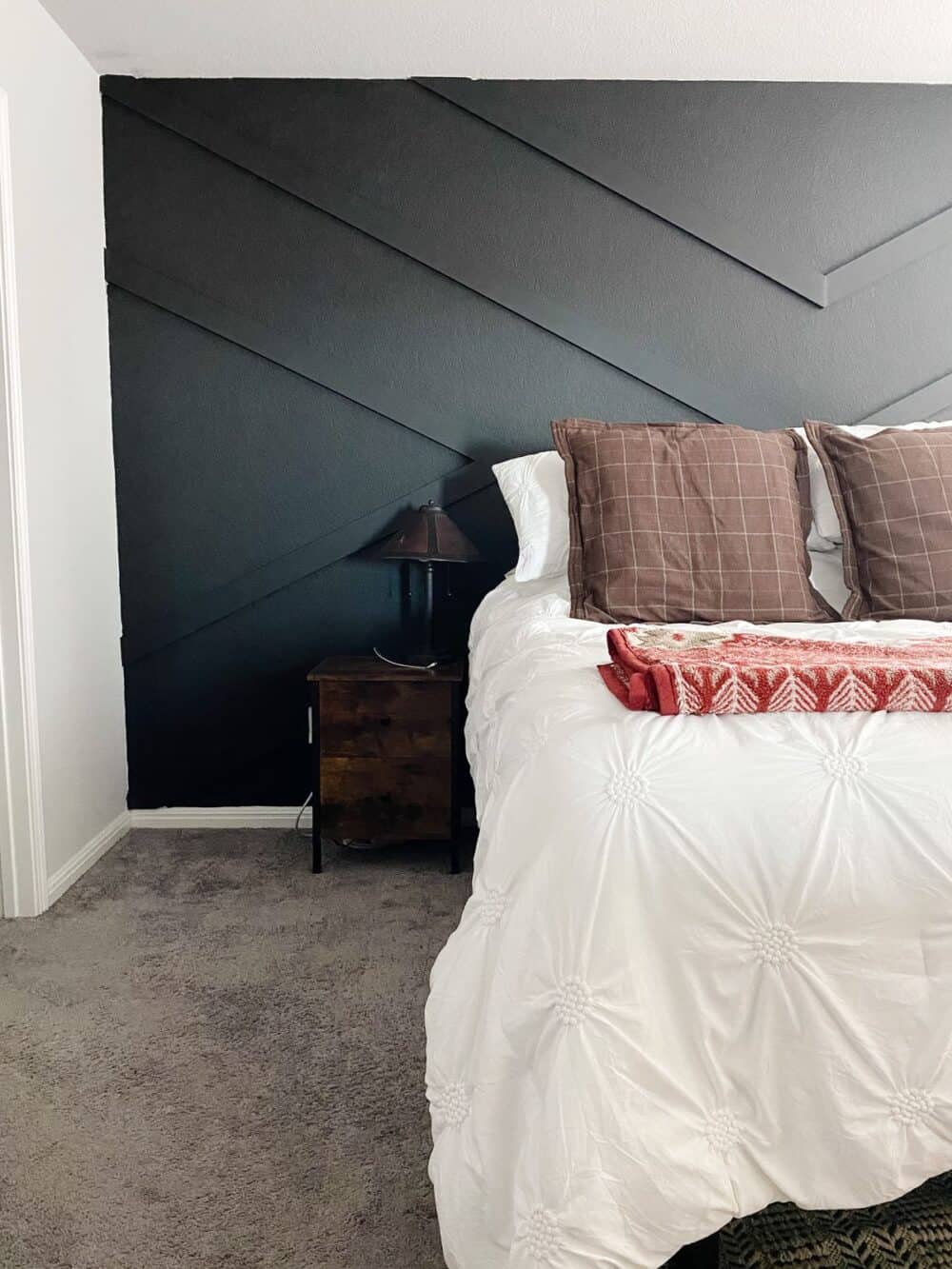 geometric accent wall in a bedroom painted black 