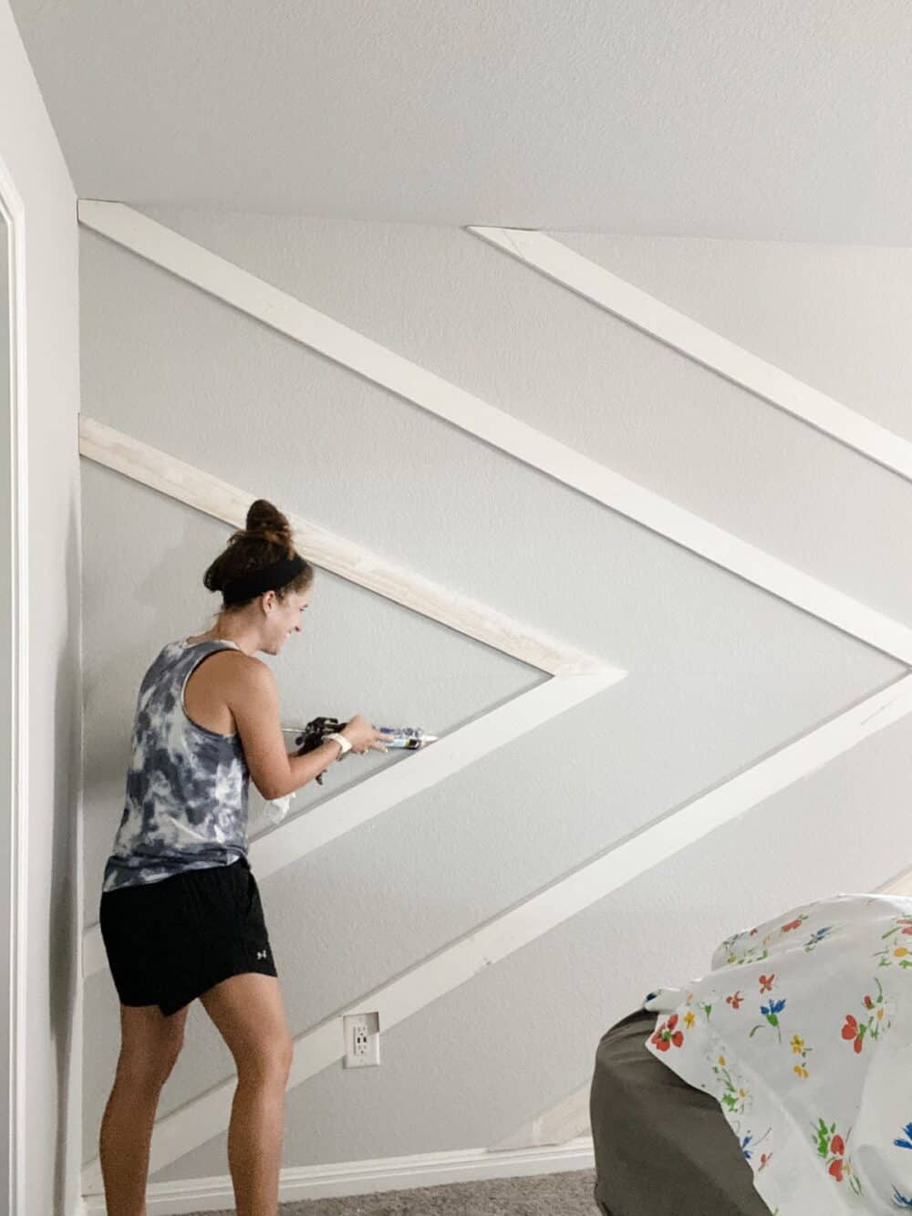 Woman adding caulk to accent wall