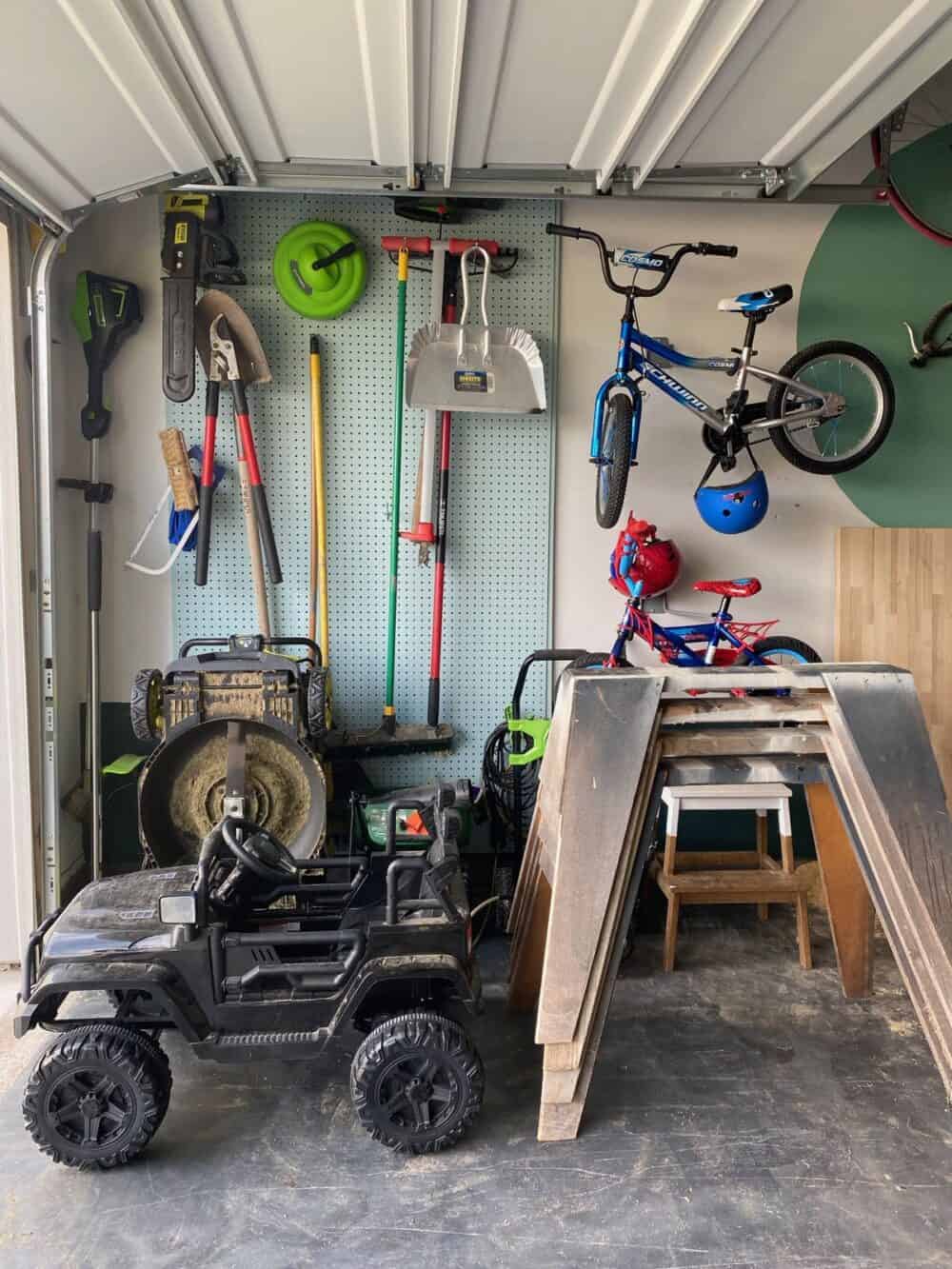 Large pegboard with lawn equipment hung on it