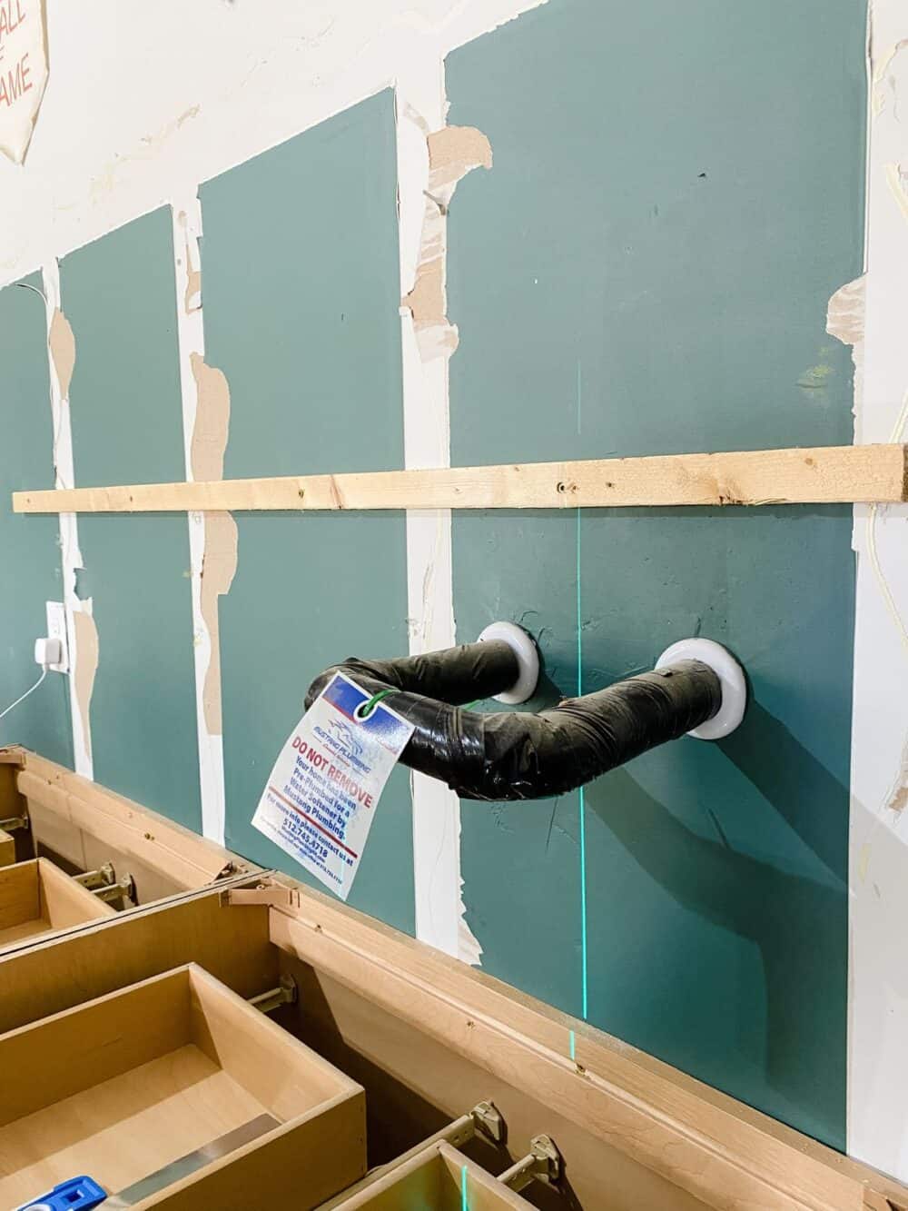 Ledger board installed on a wall for garage cabinets 