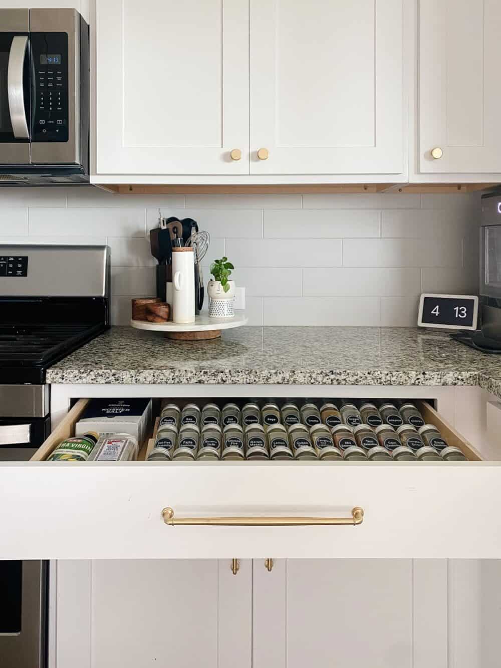Organized spice drawer in a white kitchen
