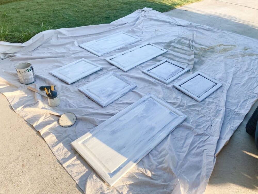 Cabinet doors laid out on a dropcloth ready to be painted