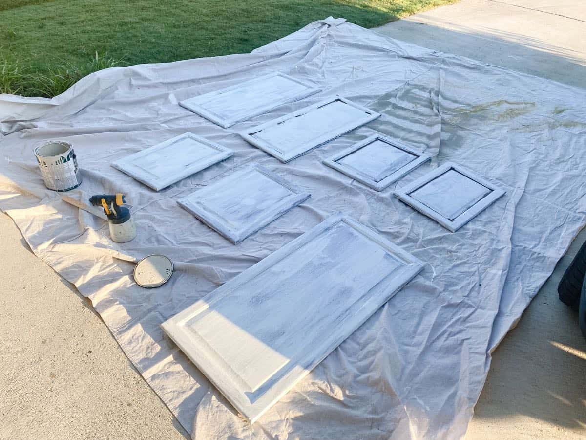 Cabinet doors laid out on a dropcloth ready to be painted