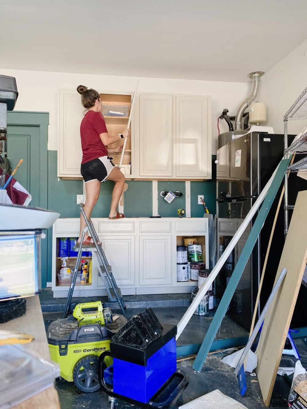 Woman installing the door on an upper cabinet 
