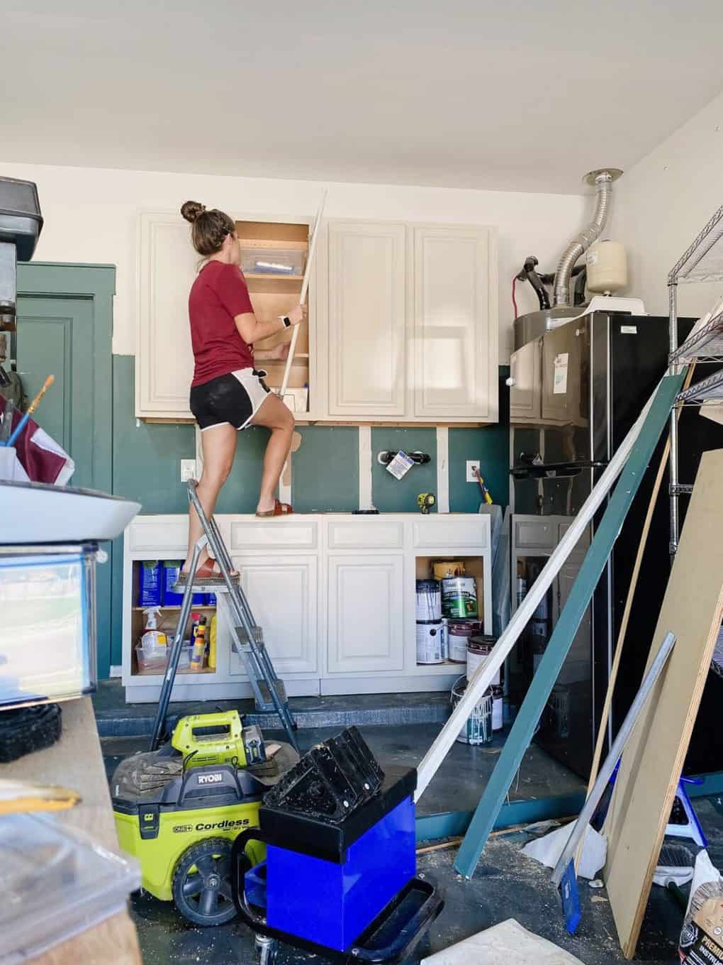 Woman installing the door on an upper cabinet
