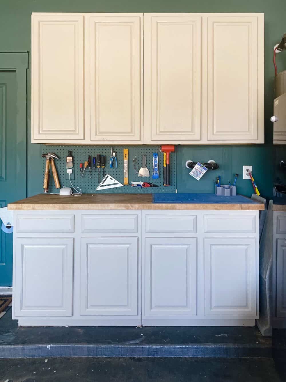 Garage cabinets with an organized pegboard between them 