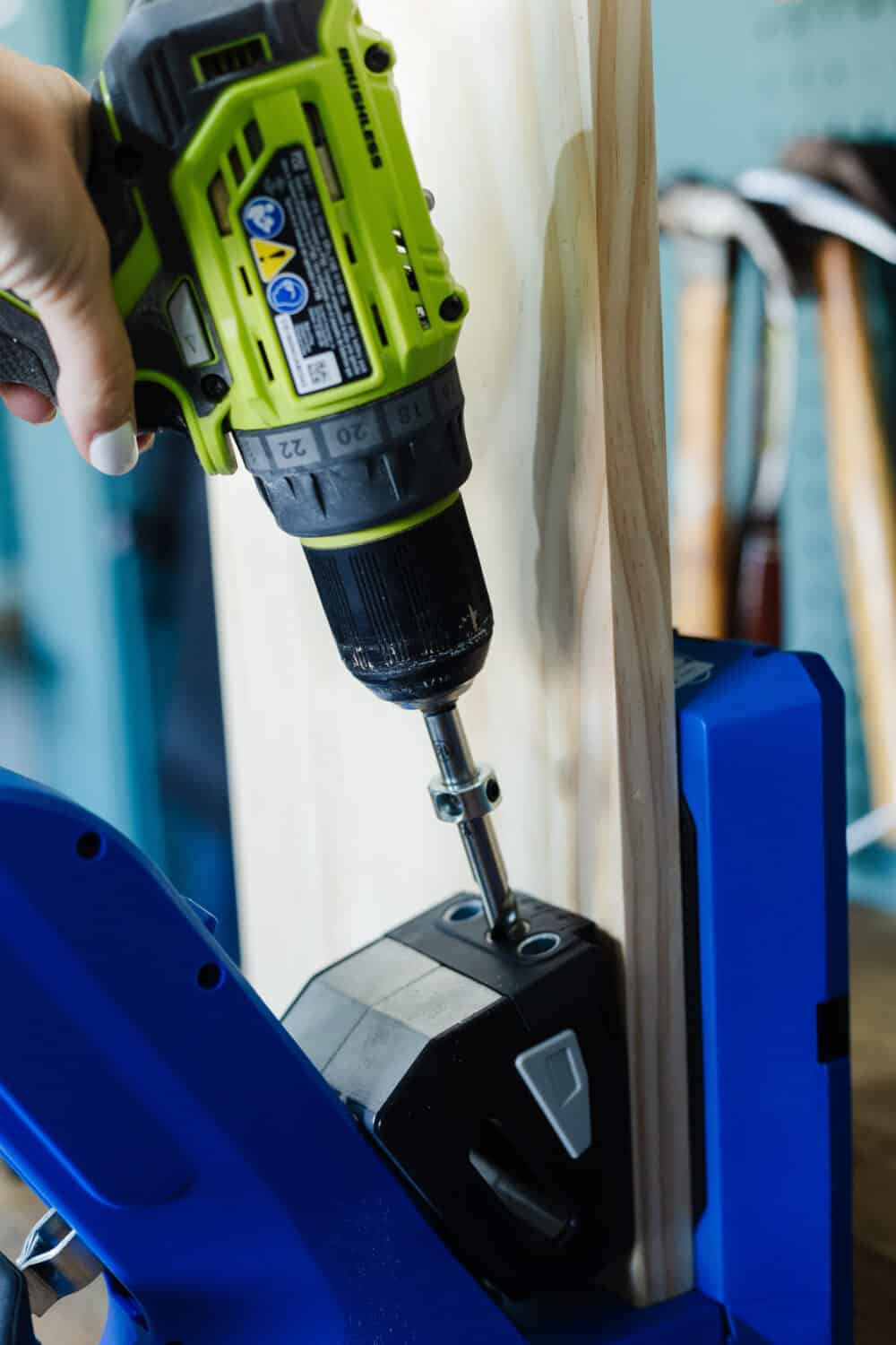 Woman's hand holding a drill and creating a pocket hole 