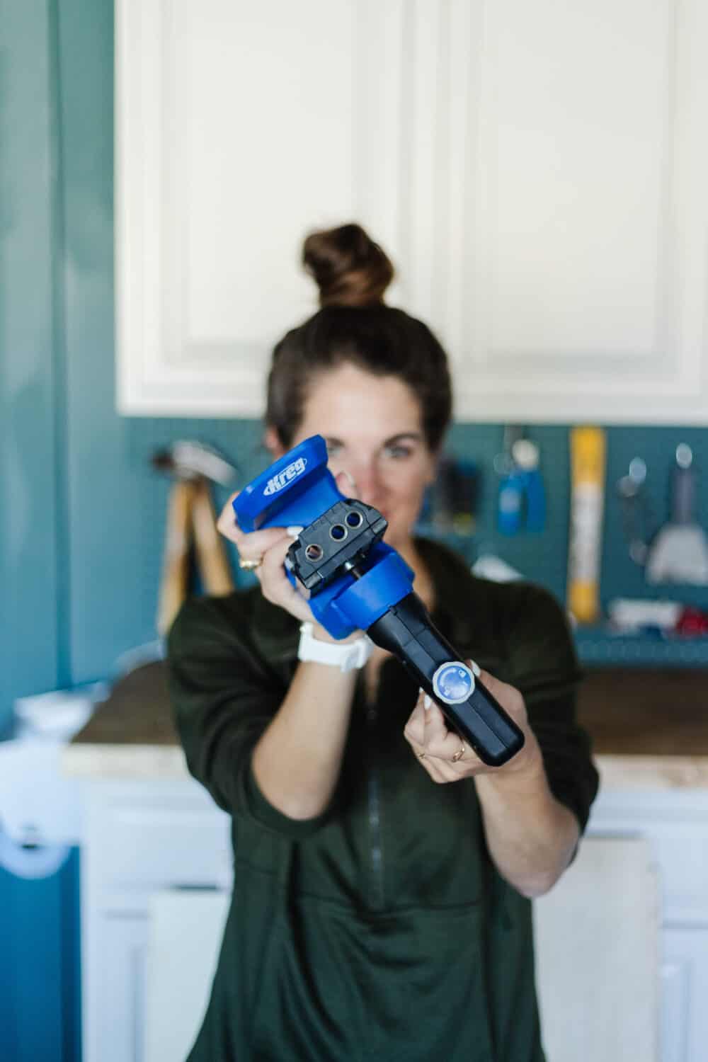 Woman holding a Kreg pocket hole jig 