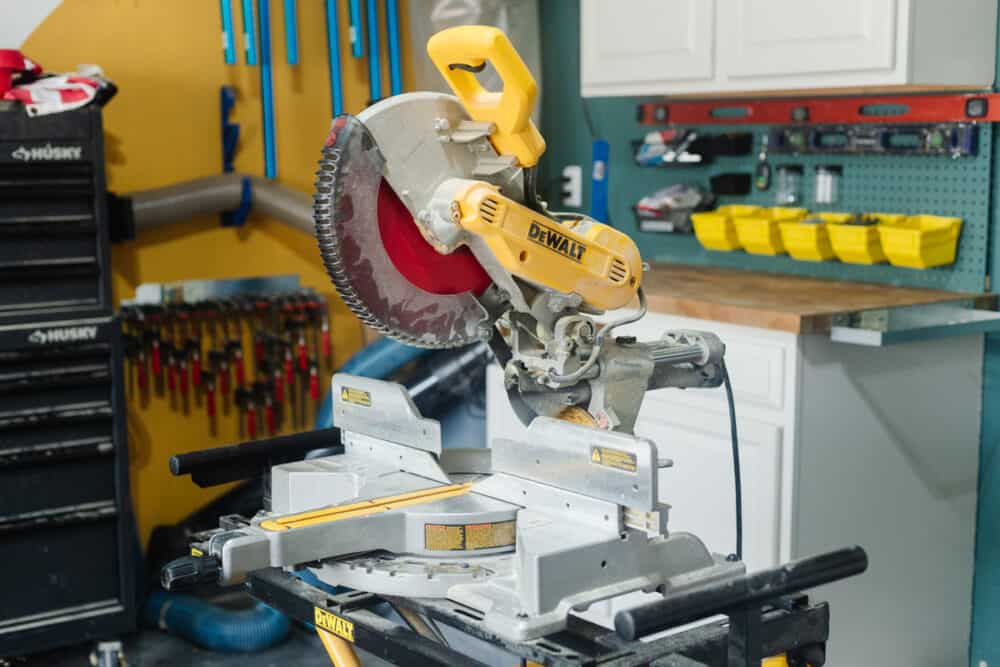 A miter saw on a stand sitting in a garage