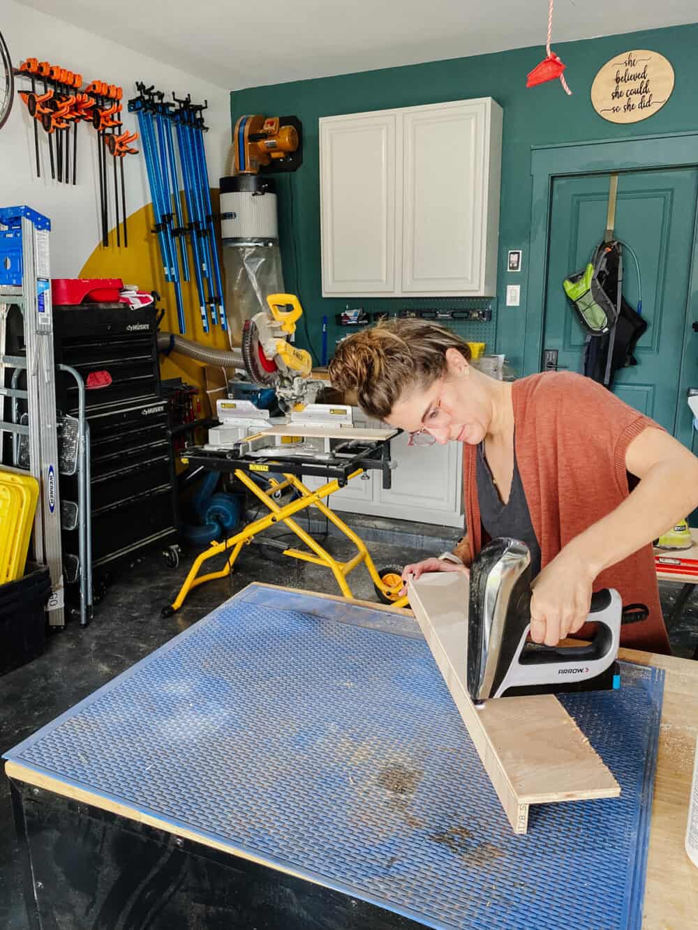 Woman using an Arrow nail gun to assemble a spice rack