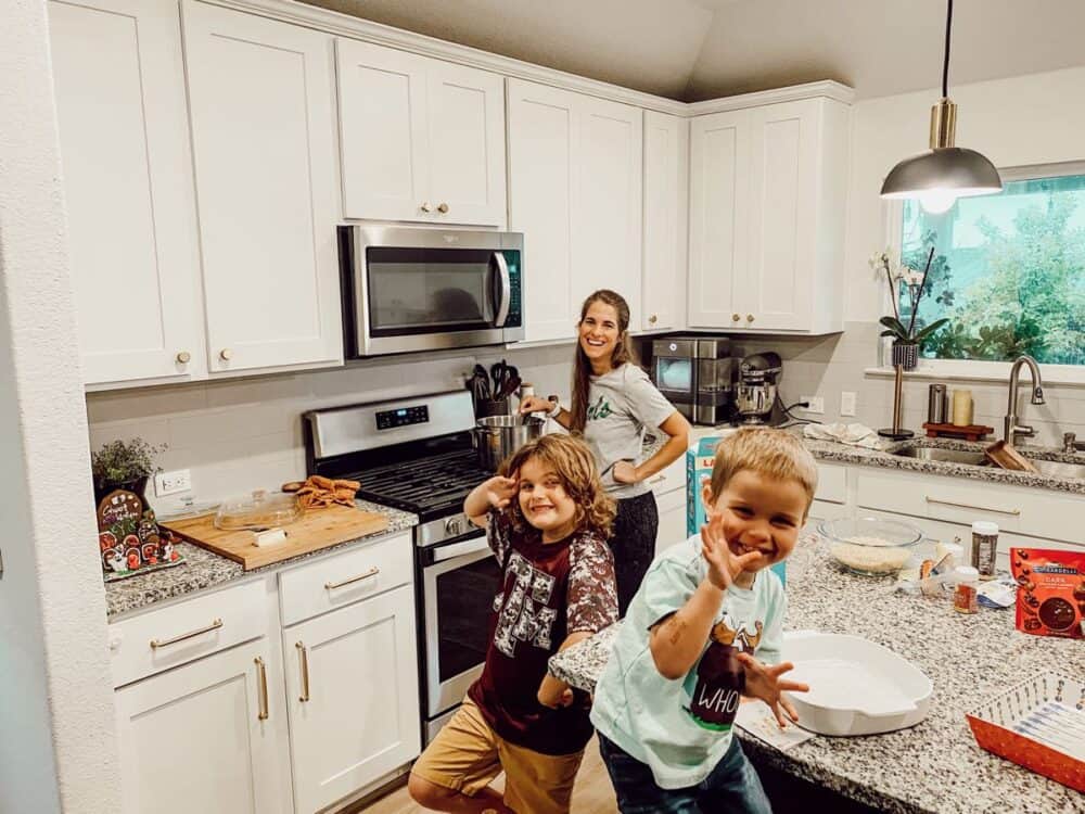 Mom and two young boys baking in a kitchen 