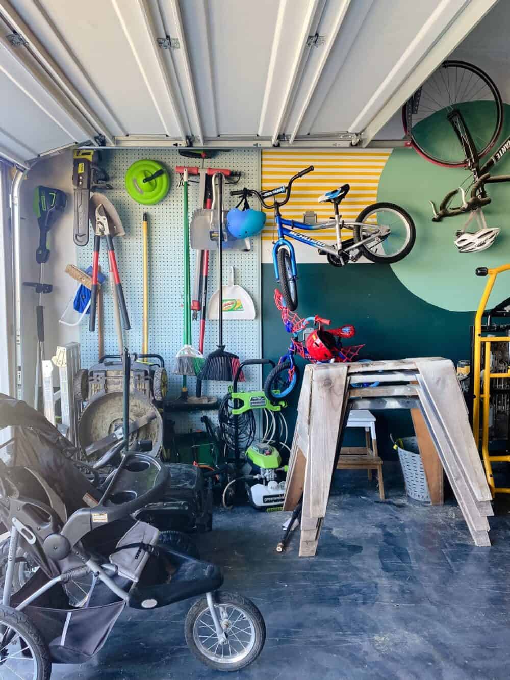 Corner of a garage with large pegboard and wall murals 