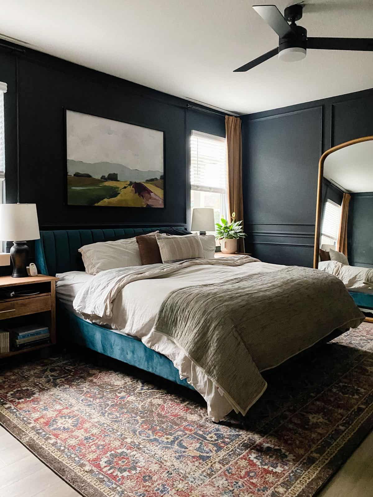 Dark blue bedroom with picture molding and a blue bed 
