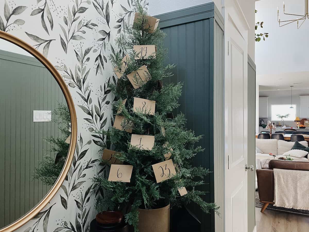 A tabletop tree with envelopes tucked into it to create a DIY advent calendar