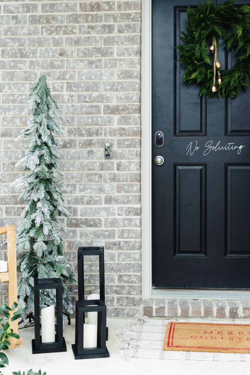 Small front porch decorated for Christmas with DIY wood lanterns