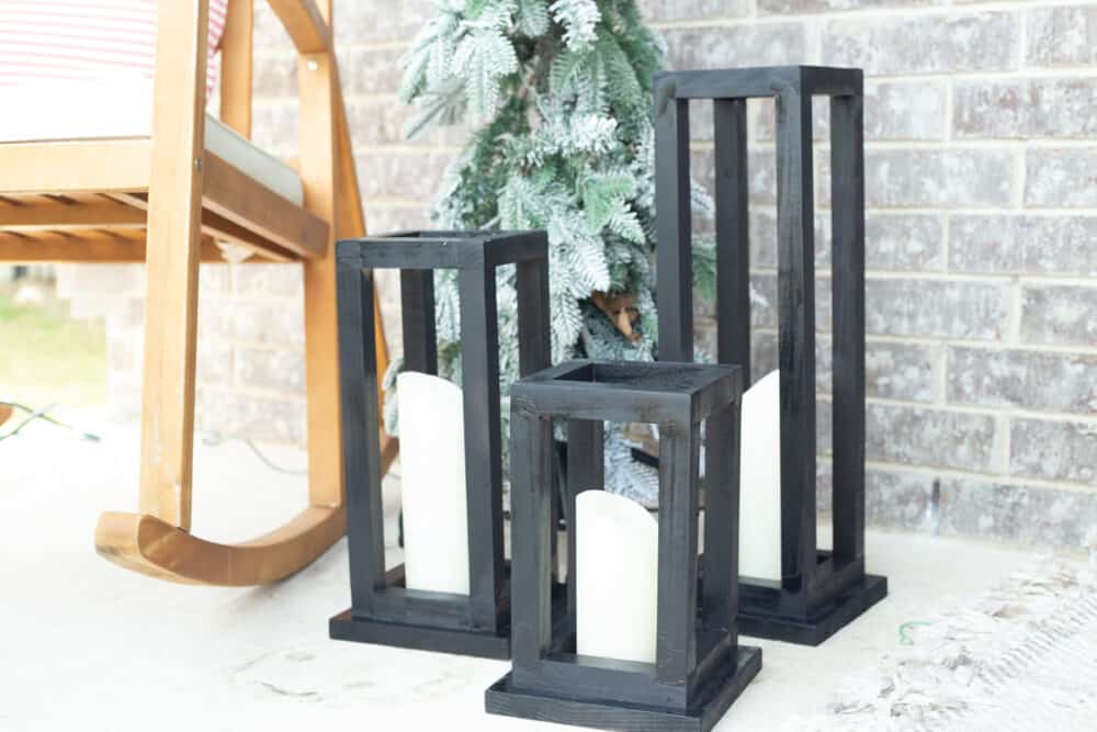 a front porch with black wood lanterns 