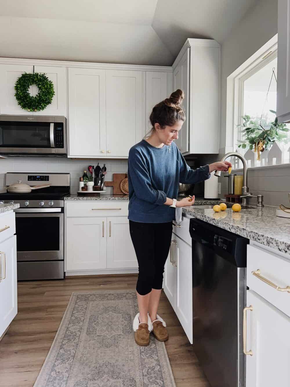 Woman cleaning a garbage disposal with lemon peels