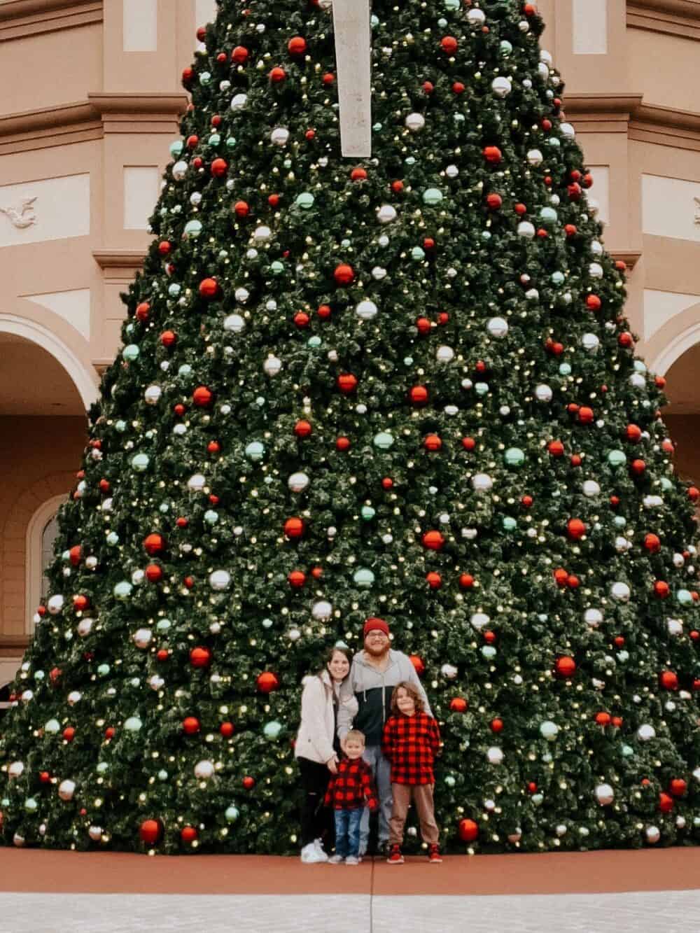 family posing for a photo in front of the Christmas tree at Sights & Sounds Theater in Branson, MO 