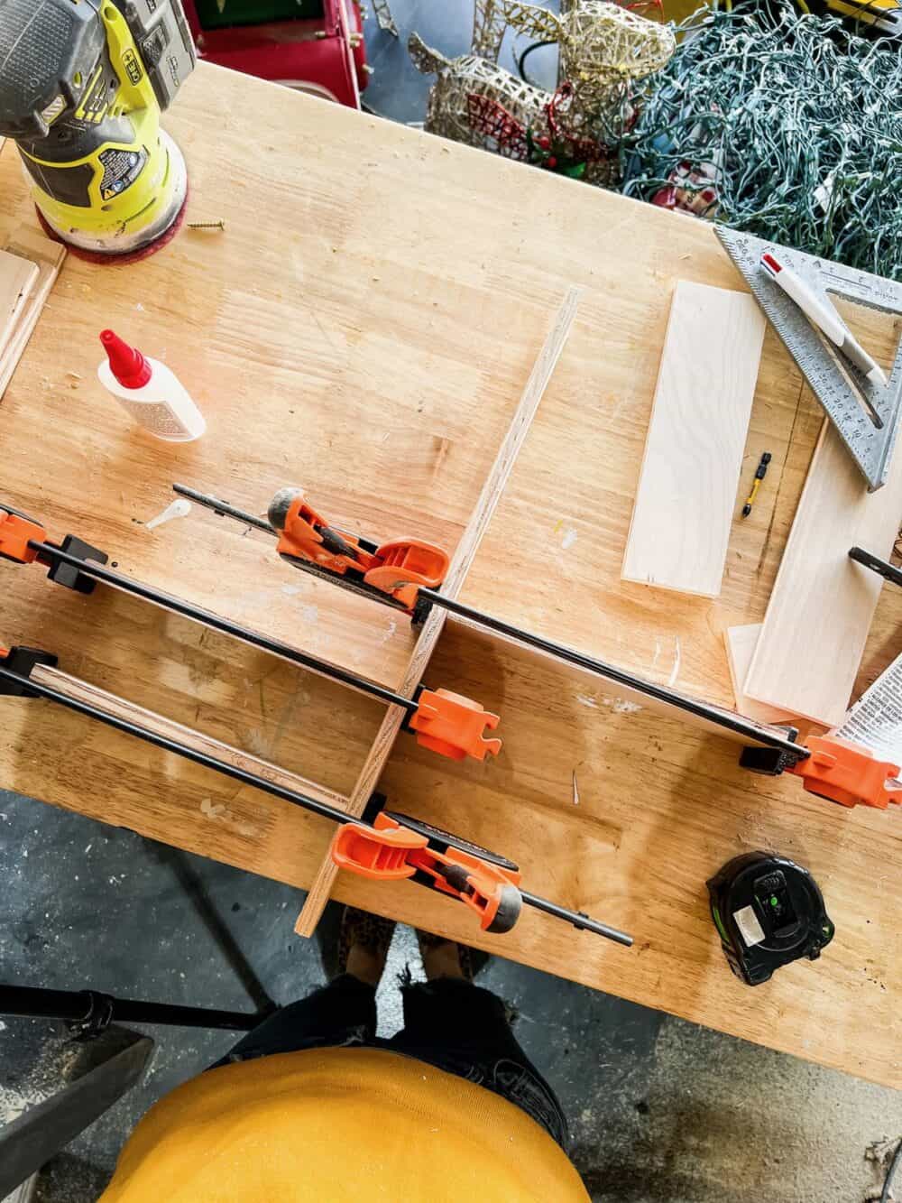 Scraps of wood clamped together to create a diy wooden drawer organizer 