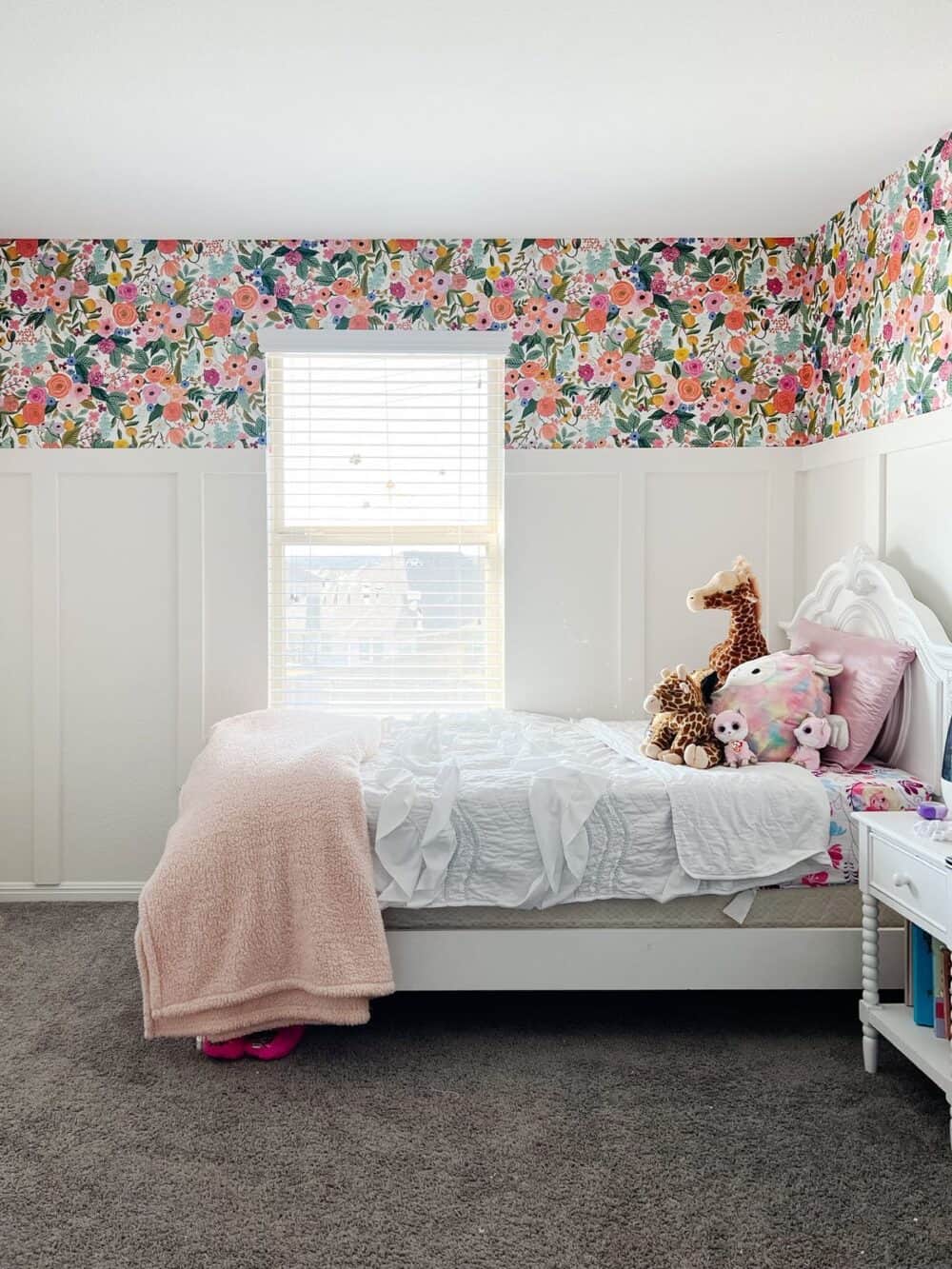 girls bedroom with board and batten walls and floral wallpaper 
