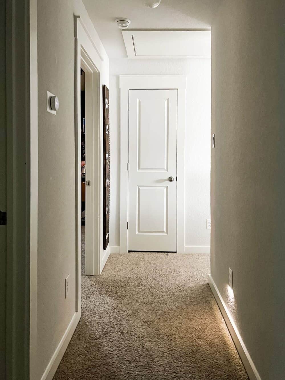 narrow hallway with a lighted outlet 