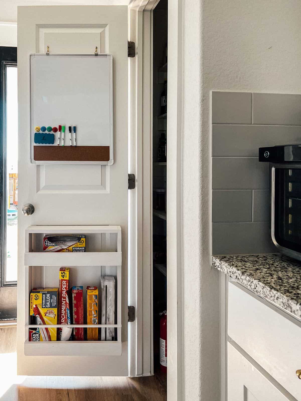 Pantry door with a whiteboard hanging on it 