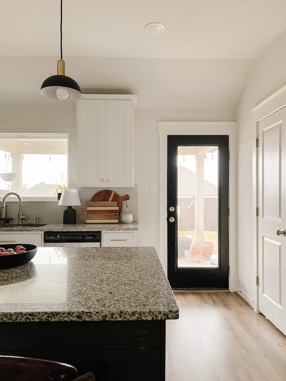 A white kitchen with a small black table lamp