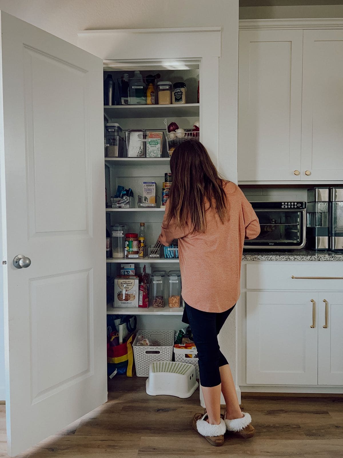 woman grabbing food out of a pantry
