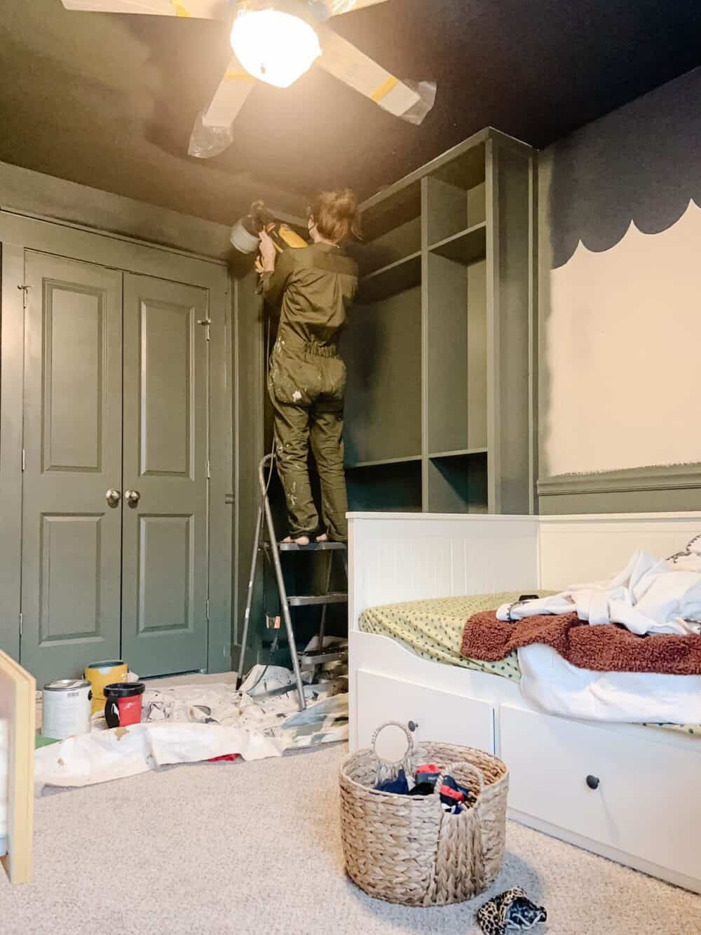 Woman painting in a room using a paint sprayer 