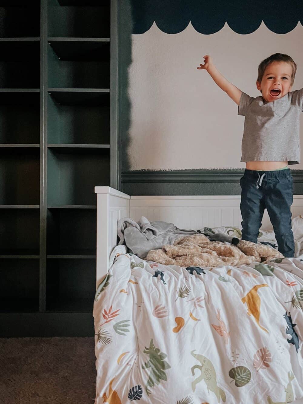 Young boy jumping on bed