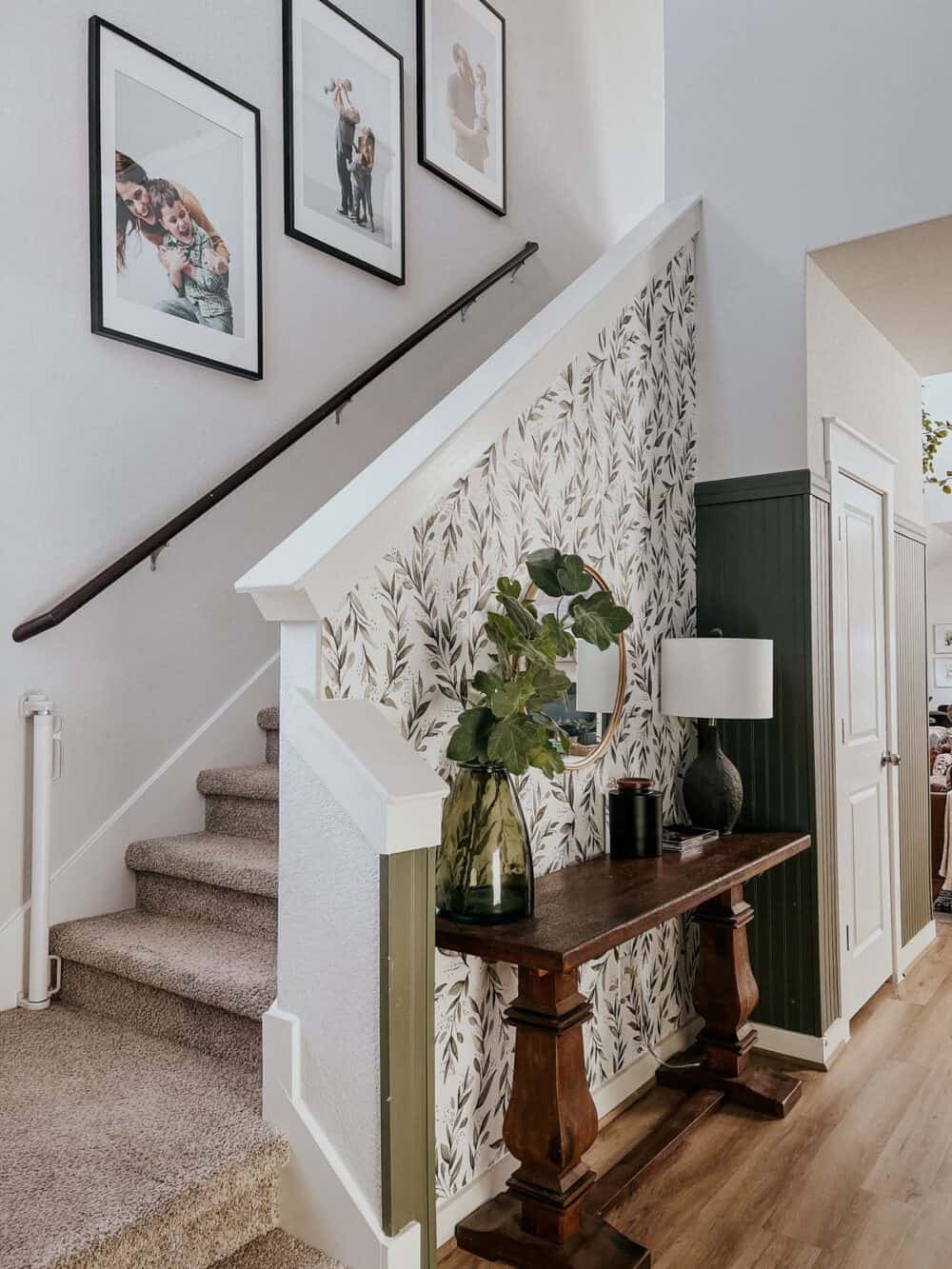 Entryway with black and white floral wallpaper and green panelinig