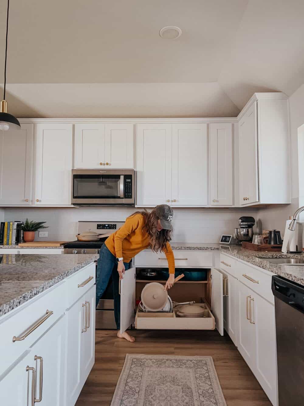 Woman grabbing a pan from an organized cabinet