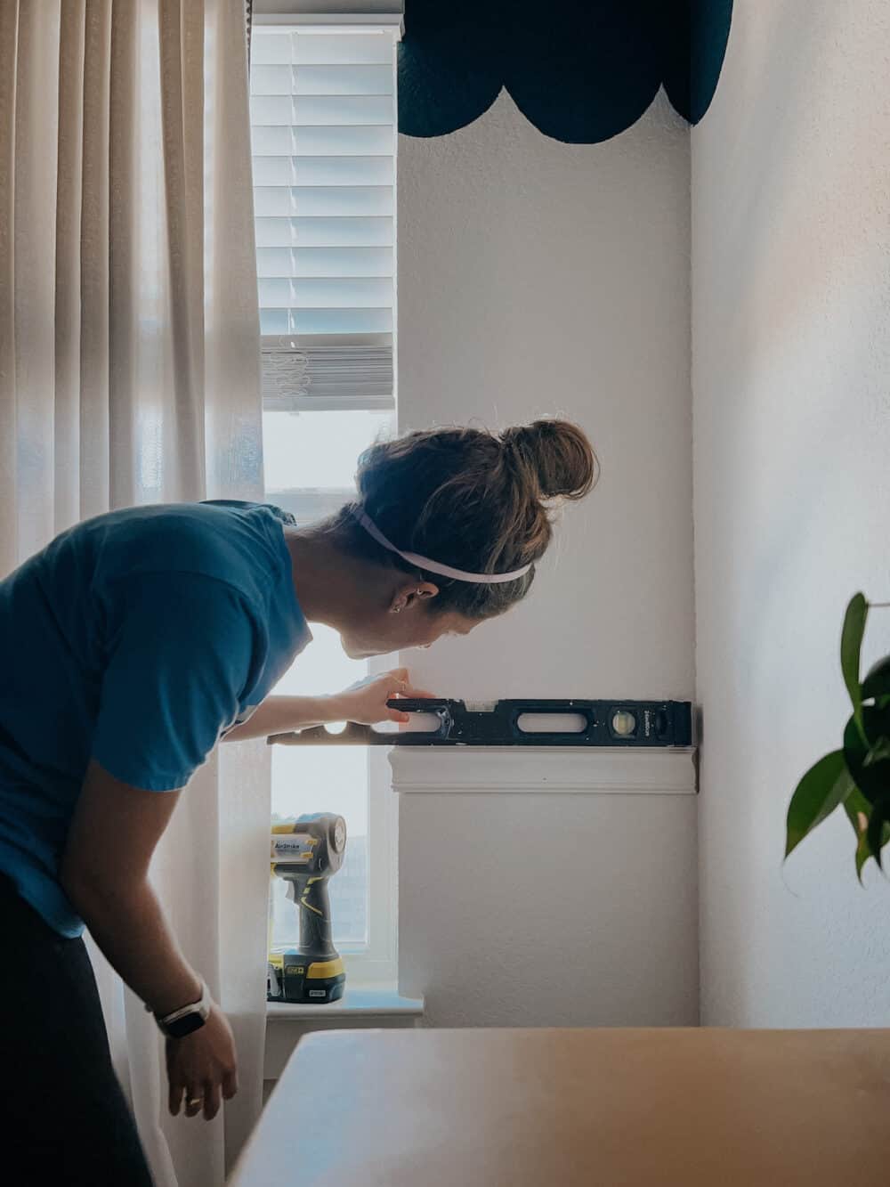 Woman installing chair rail molding in a kids' room.