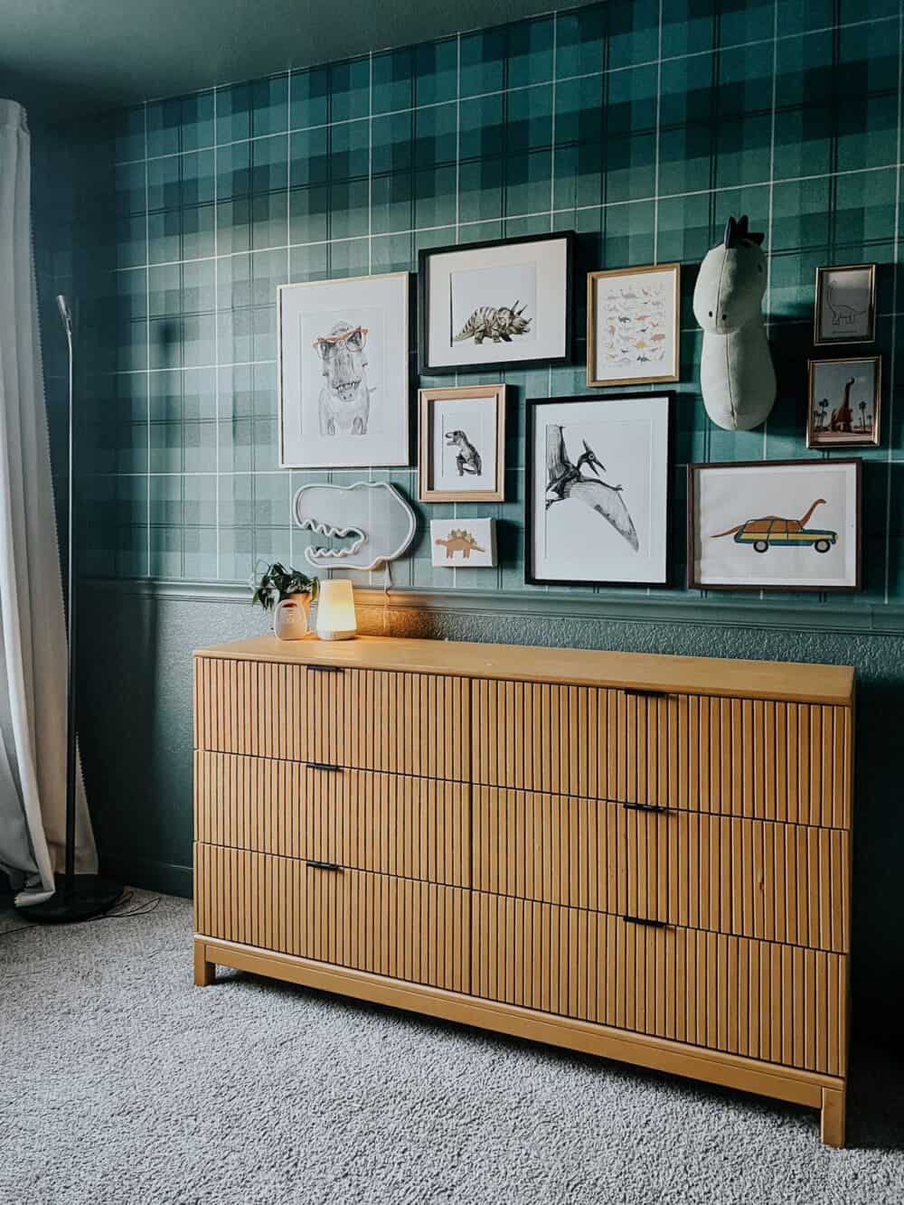 boys room with green walls and a dinosaur themed gallery wall