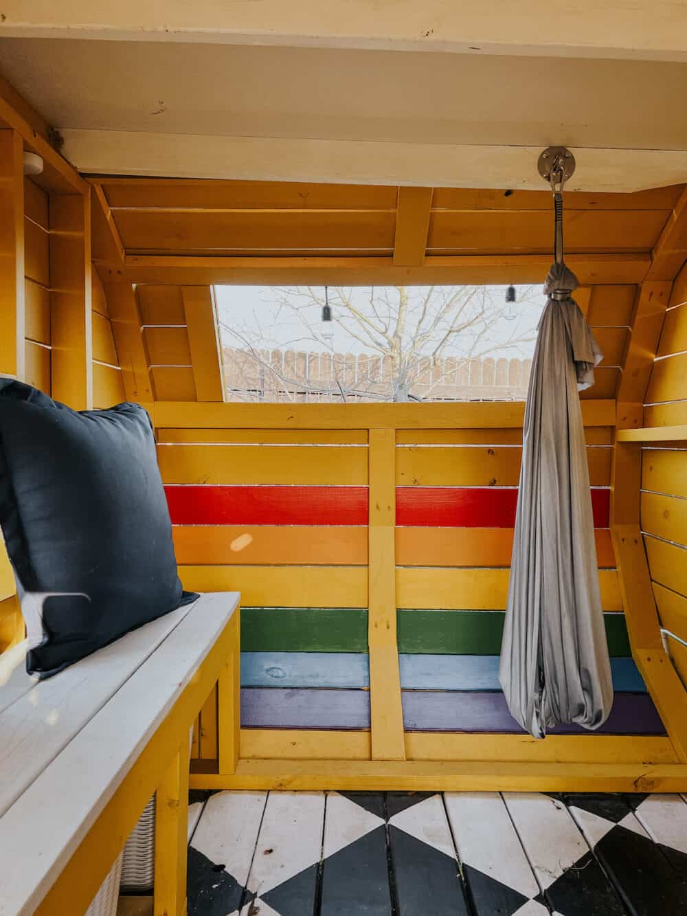 playhouse with a rainbow stripe painted onto the walls