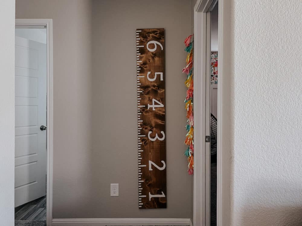 Wooden growth chart hanging in a play room