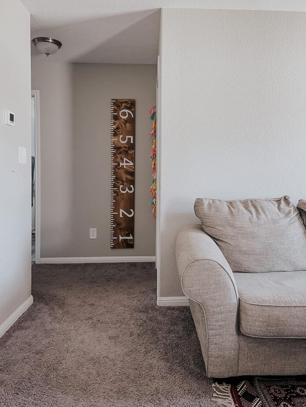 Hallway with a wooden growth chart hanging on the wall 