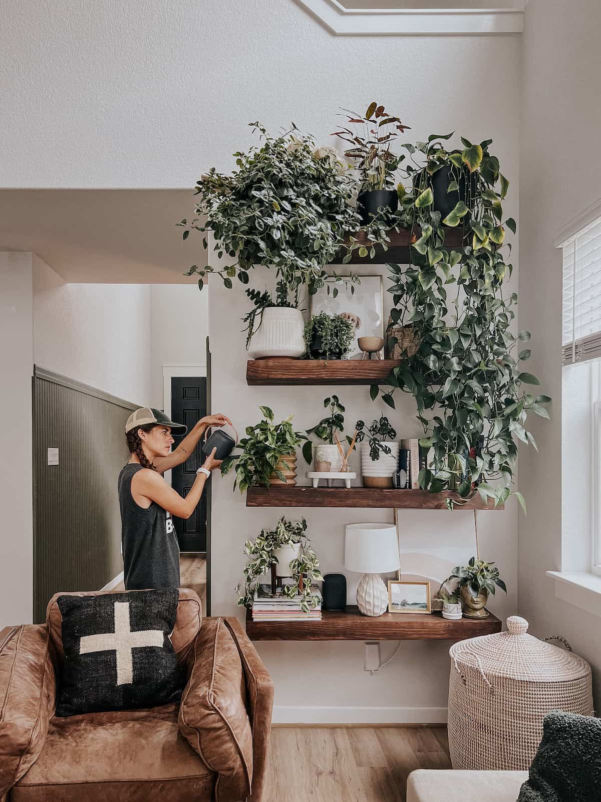 Woman watering plants on a plant shelf 
