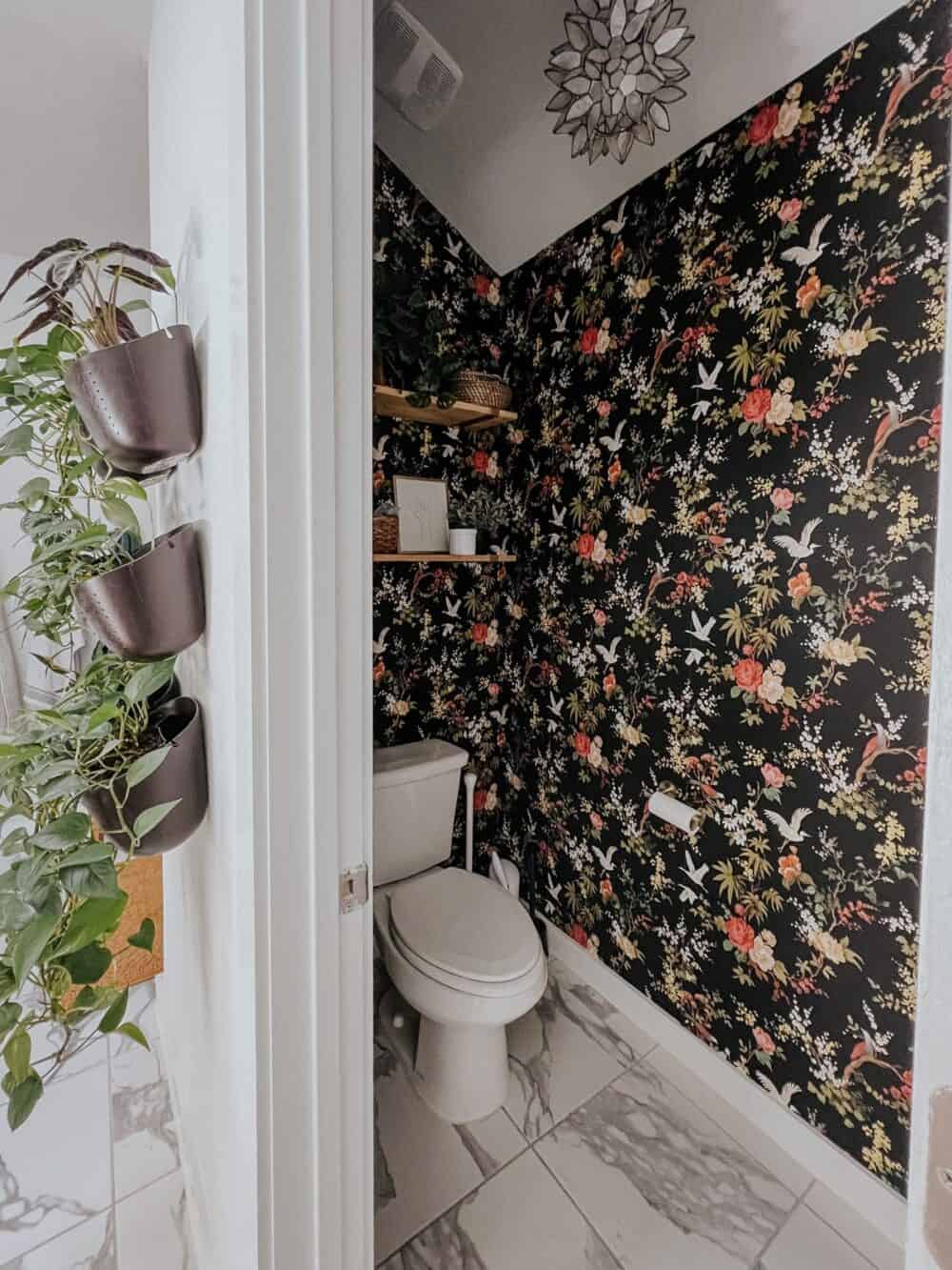 Bathroom water closet with black floral wallpaper 
